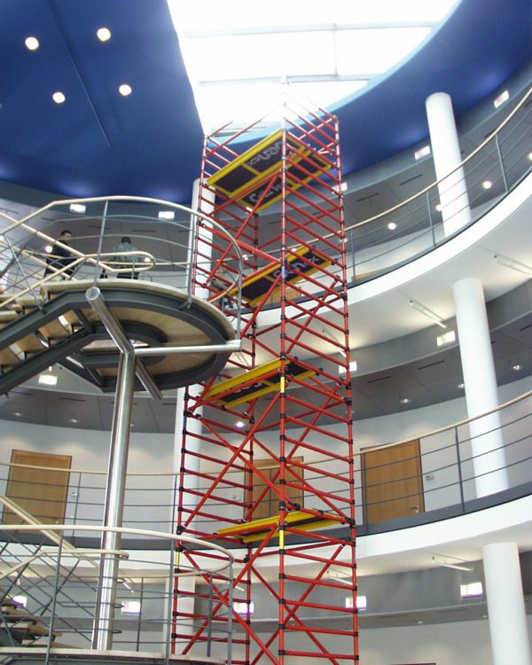 Tall scaffolding structure inside a modern building atrium under construction.
